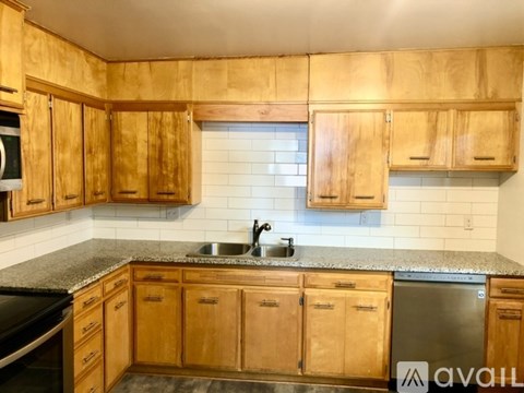 A kitchen with wooden cabinets and a granite countertop.