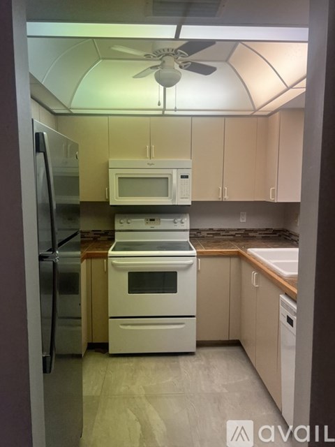 A kitchen with a refrigerator, microwave, oven, and dishwasher.