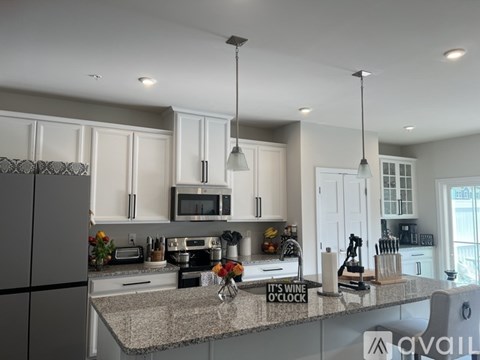 A kitchen with a granite countertop and a microwave above it.