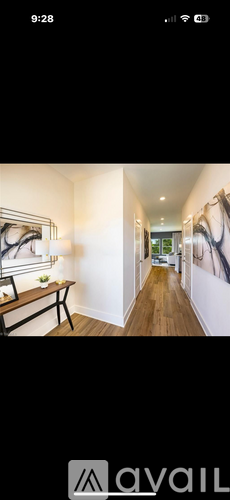 A long, narrow hallway with a bench and a painting on the wall.