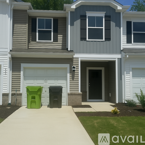 A house with a grey and white exterior and a green trash can in front of it.
