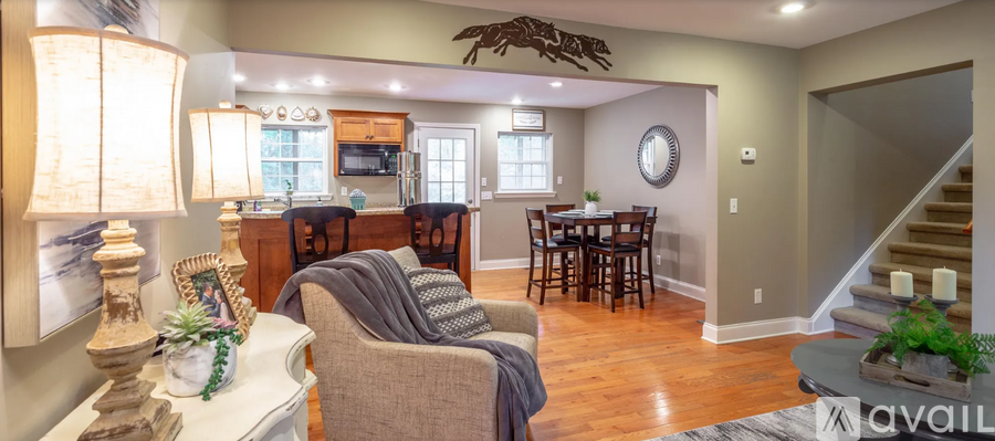 A living room with a couch, chairs, and a dining table.