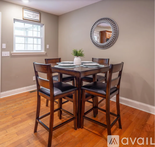 A dining room with a wooden table and chairs.