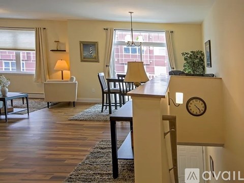 A living room with a couch, chair, and a table with a lamp.