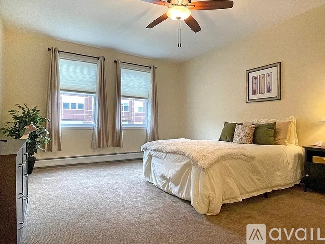 A bedroom with a large bed and a ceiling fan.