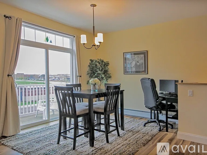 A dining room with a table set for four and a balcony with a view of the city.