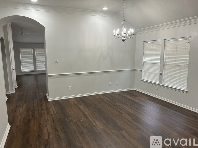 A room with wooden floors and a chandelier.