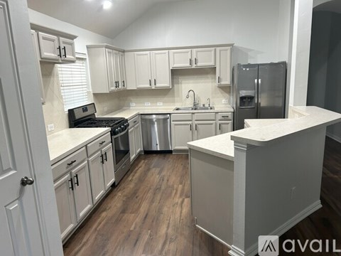 A kitchen with white cabinets and a white island.