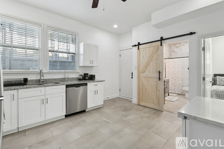 A kitchen with white cabinets and a marble countertop.