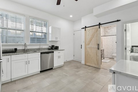 A kitchen with white cabinets and a marble countertop.