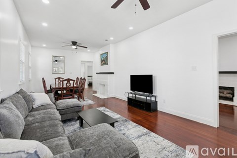 A living room with a grey sofa and a black television.
