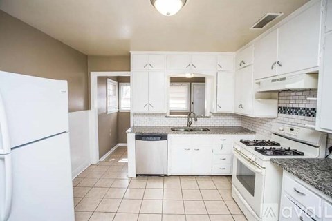 A kitchen with white appliances and cabinets.