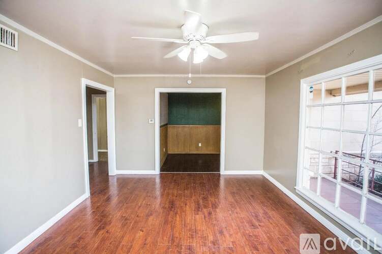 A room with wooden floors and a ceiling fan.