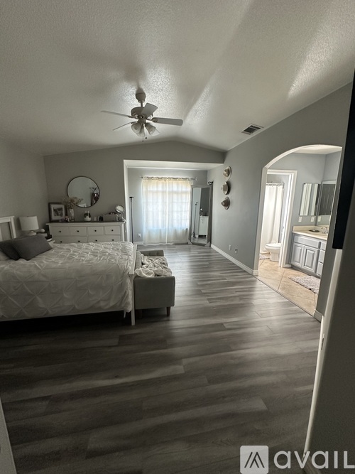A bedroom with a bed, dresser, and window with blinds.