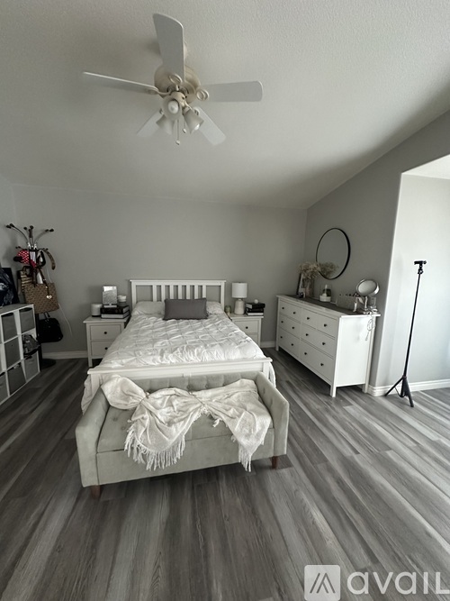 A bedroom with a large bed and a ceiling fan.