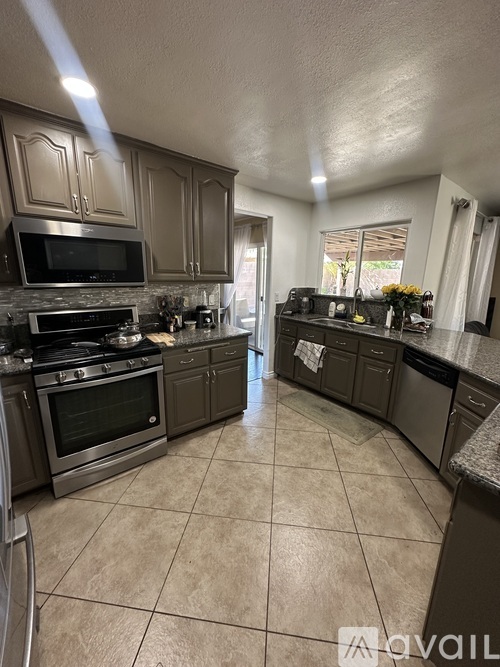 A kitchen with a tile floor and a stove top oven.