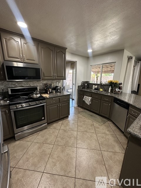 A kitchen with a tile floor and a stove top oven.