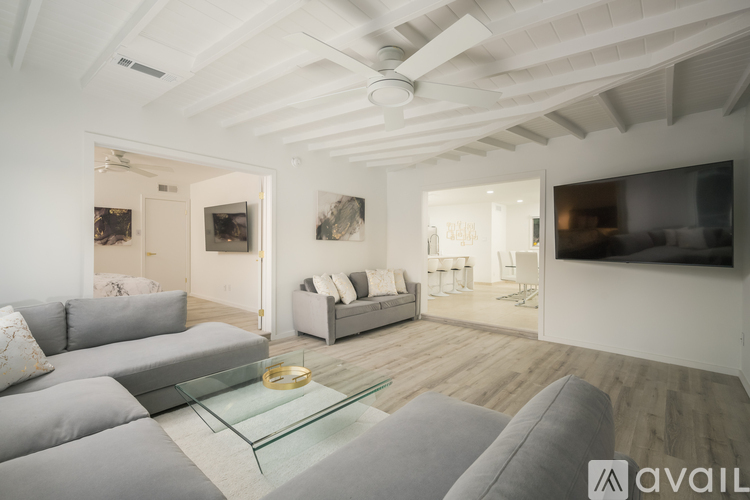 A modern living room with a grey sofa and a glass coffee table.