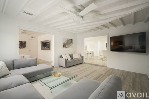 A modern living room with a grey sofa and a glass coffee table.