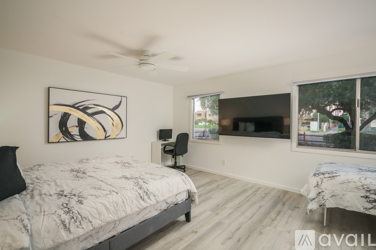 A bedroom with a large bed and a ceiling fan.