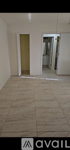 A room with a tiled floor and a doorway leading to another room.