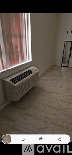 A room with a window and a radiator on the floor.