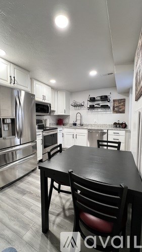 A modern kitchen with a dining table and chairs.