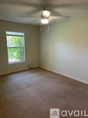 A room with a window and a ceiling fan.