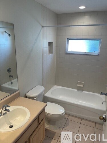 A bathroom with a toilet, sink, and bathtub.