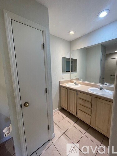 A bathroom with a white door, a sink, and a mirror.