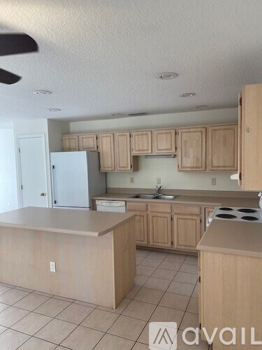 A kitchen with wooden cabinets and a white refrigerator.