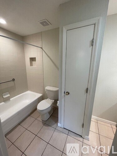 A white bathroom with a toilet, tub, and sink.