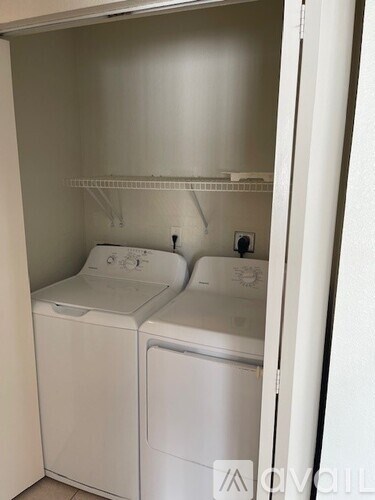 A white washing machine and dryer in a small laundry room.