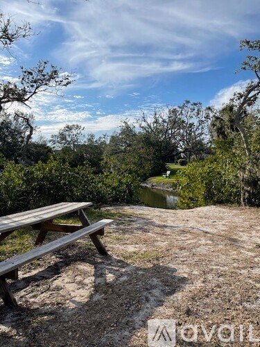A picnic table sits on a hillside overlooking a river.