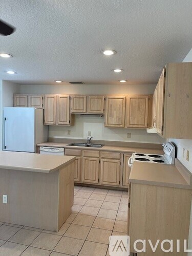 A kitchen with wooden cabinets and a white fridge.