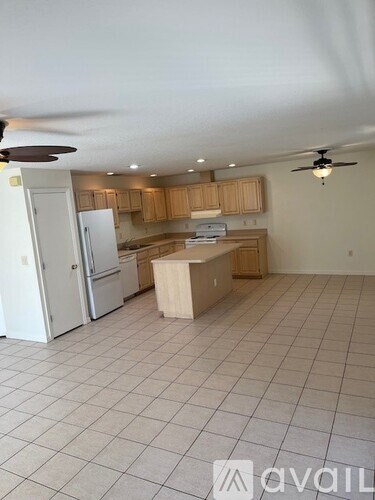 A kitchen with white appliances and wooden cabinets.