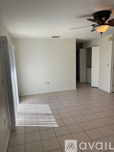 A room with a ceiling fan and tiled floor.