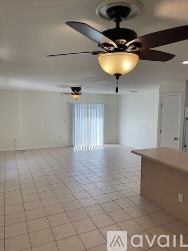 A room with a ceiling fan and tiled flooring.