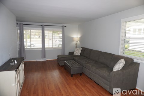 A living room with a grey couch and a wooden floor.