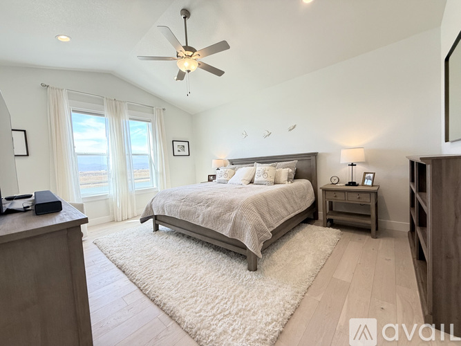 A bedroom with a large bed and a ceiling fan.