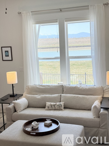A living room with a couch, a table with a tray and two lamps.
