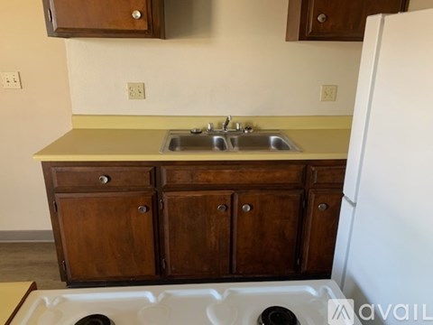 A kitchen area with brown carpeting and white walls.