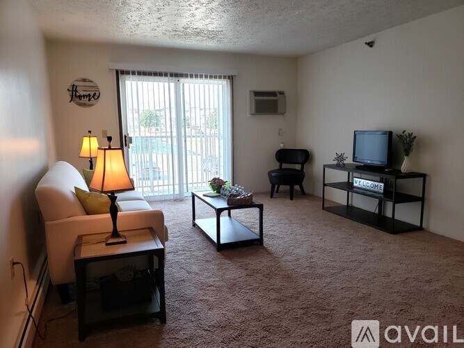A living room with a couch, chair, and television.