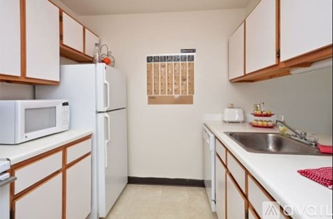 A kitchen with white appliances and wooden cabinets.