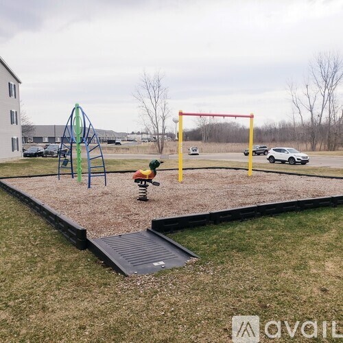 A playground with a slide, swings, and a seesaw.