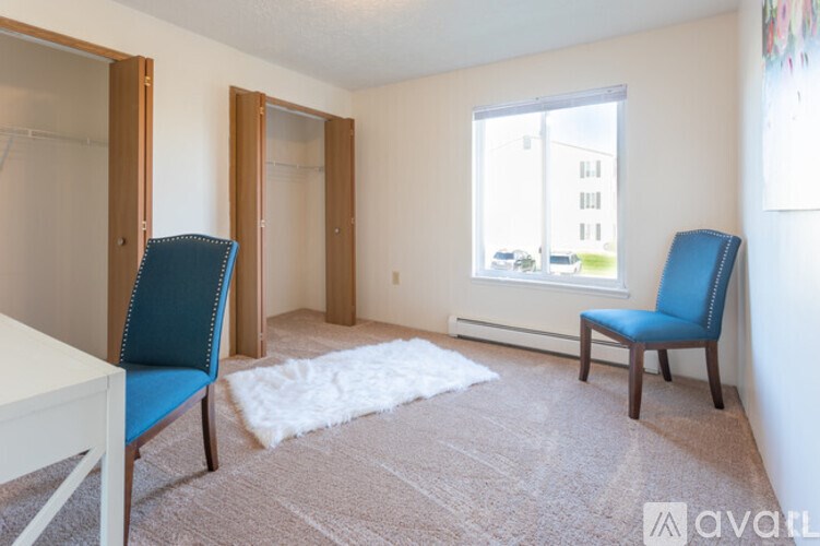 A room with a blue chair and a white table.
