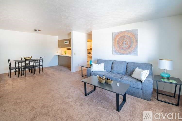 A living room with a grey couch, a coffee table, and a dining table with chairs.