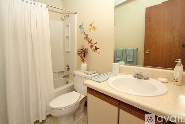 A bathroom with a toilet, sink, and shower.