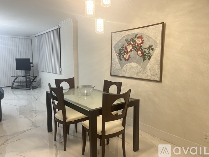 A dining room with a glass table and chairs.