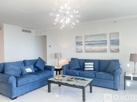 A living room with a blue couch and a coffee table.